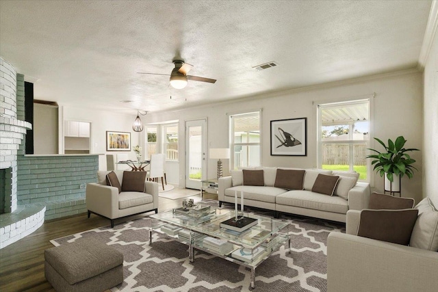 living room featuring a textured ceiling, plenty of natural light, ceiling fan, and dark hardwood / wood-style floors