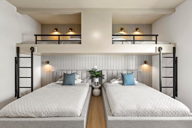 bedroom featuring beamed ceiling and hardwood / wood-style flooring