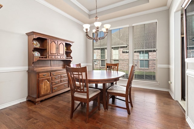 dining room featuring a chandelier, dark hardwood / wood-style floors, crown molding, and a tray ceiling