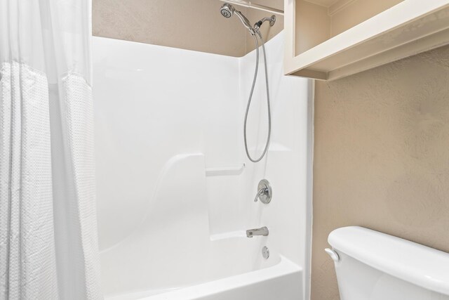 bathroom with shower / bath combo and toilet