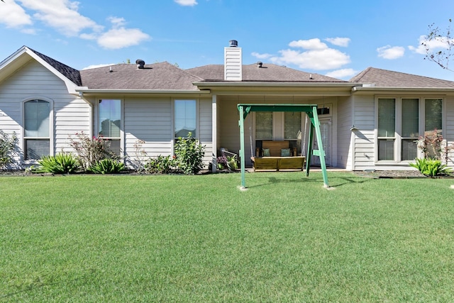 rear view of property featuring a yard