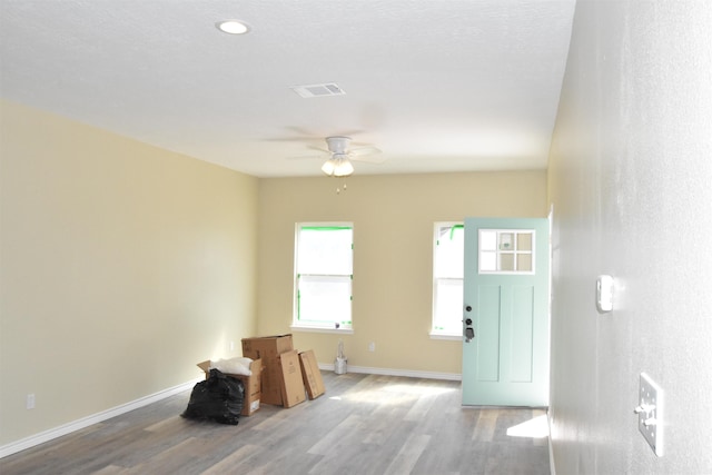 interior space featuring visible vents, ceiling fan, baseboards, and wood finished floors