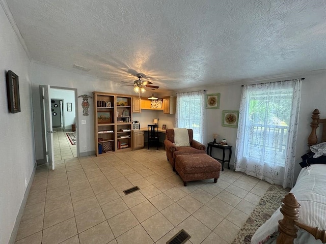 living room featuring ceiling fan, light tile patterned floors, and a textured ceiling