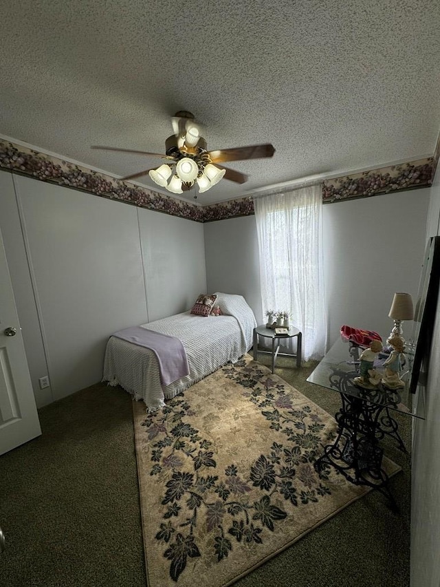 carpeted bedroom featuring ceiling fan and a textured ceiling