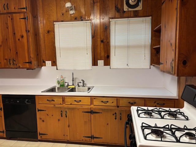 4609 Alamosa St, Port Arthur, TX 77642 - kitchen with white gas range, black dishwasher, a sink, light countertops, and brown cabinets