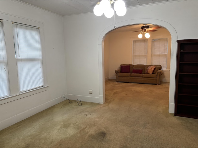 4609 Alamosa St, Port Arthur, TX 77642 - unfurnished living room with arched walkways, carpet flooring, ornamental molding, a ceiling fan, and baseboards