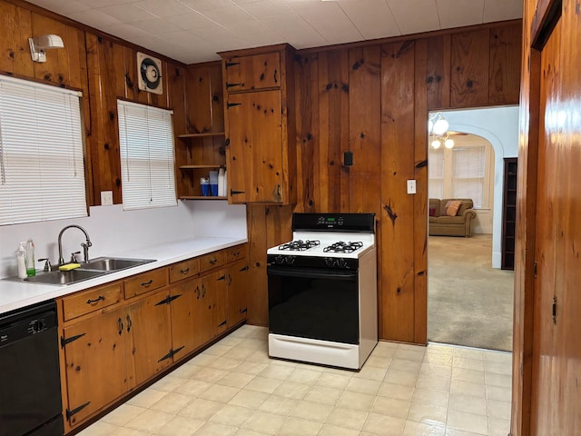 4609 Alamosa St, Port Arthur, TX 77642 - kitchen featuring gas stove, black dishwasher, a sink, wood walls, and light countertops