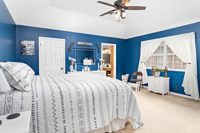 bedroom featuring carpet flooring, ceiling fan, connected bathroom, and a tray ceiling