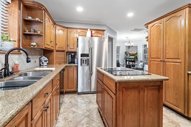 kitchen with stainless steel fridge, black electric stovetop, sink, a chandelier, and a center island