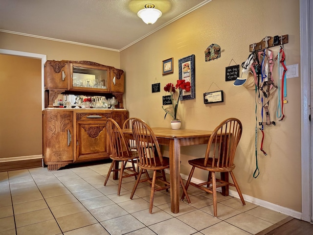 tiled dining space featuring a textured ceiling and ornamental molding