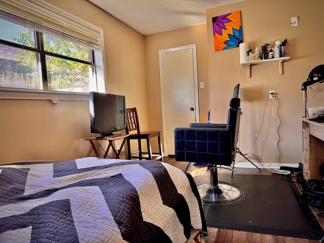 bedroom with hardwood / wood-style floors and a textured ceiling