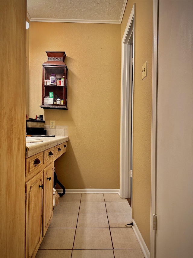 clothes washing area featuring crown molding, light tile patterned floors, and a textured ceiling