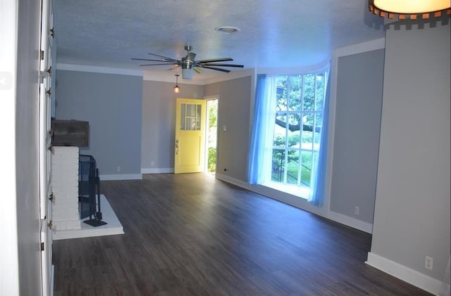 unfurnished living room with dark wood-type flooring, a brick fireplace, ceiling fan, and ornamental molding