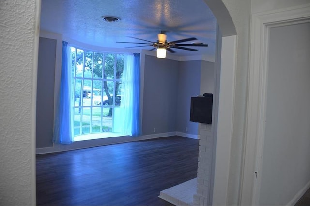 empty room featuring dark hardwood / wood-style flooring, a textured ceiling, and ceiling fan