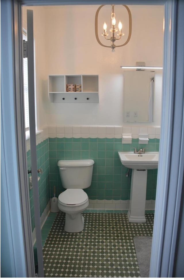 bathroom featuring sink, an inviting chandelier, tile walls, tile patterned flooring, and toilet