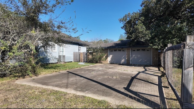 view of front of house with a garage and cooling unit