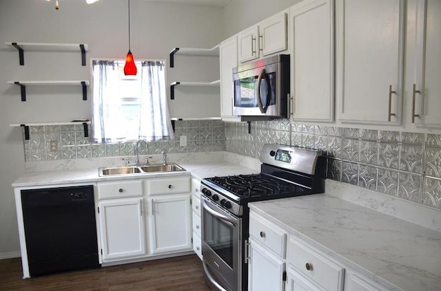 kitchen featuring decorative backsplash, appliances with stainless steel finishes, sink, white cabinets, and hanging light fixtures