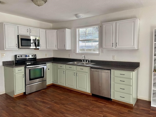 kitchen featuring white cabinets, dark hardwood / wood-style flooring, stainless steel appliances, and sink