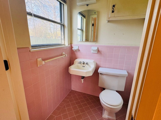 bathroom featuring tile patterned flooring, toilet, tile walls, and sink