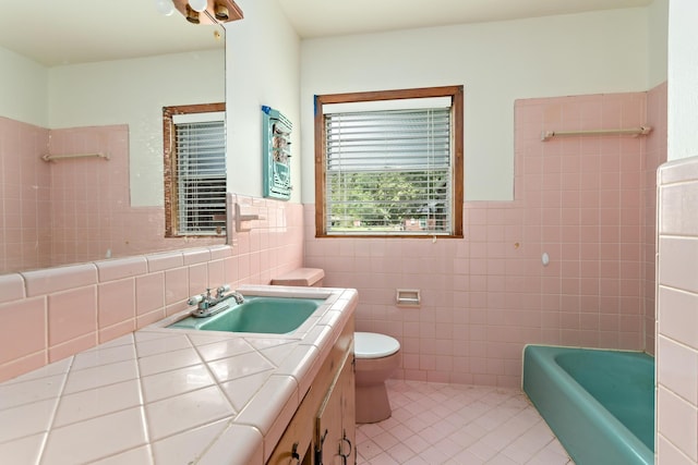 3785 Stanley Dr, Vidor, TX 77662 - bathroom with tile walls, tile patterned flooring, vanity, a bathtub, and a wainscoted wall