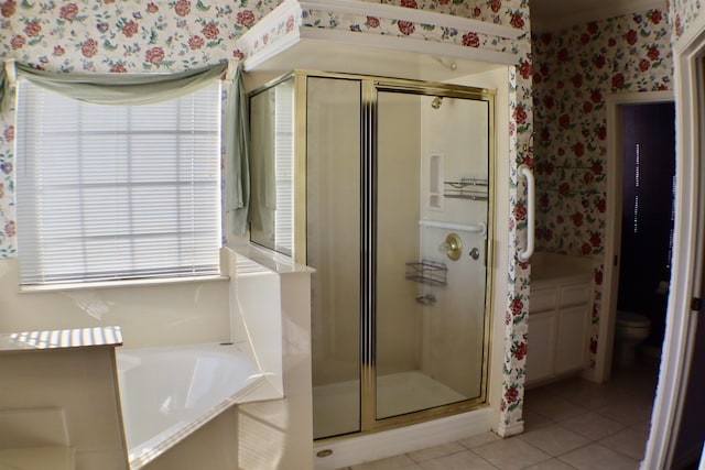 bathroom featuring toilet, shower with separate bathtub, and tile patterned flooring