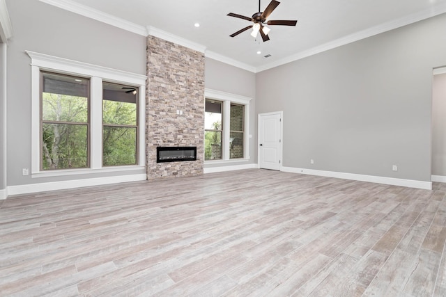 7705 Water Edge, Beaumont, TX 77707 - unfurnished living room featuring ceiling fan, light wood-type flooring, ornamental molding, a stone fireplace, and baseboards