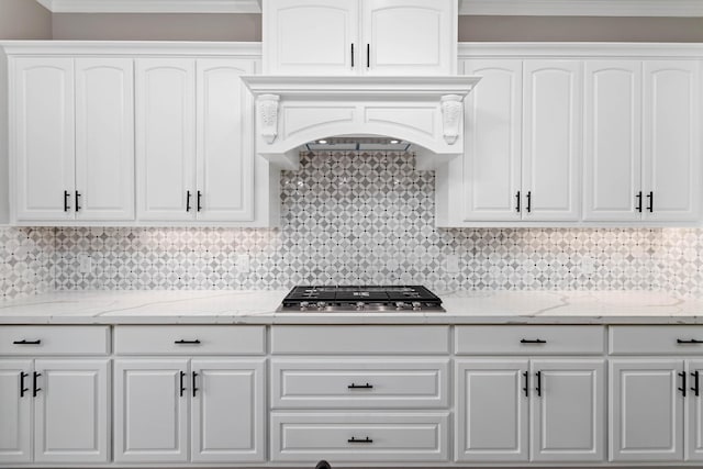 7705 Water Edge, Beaumont, TX 77707 - kitchen with white cabinetry, stainless steel gas stovetop, light stone countertops, and decorative backsplash