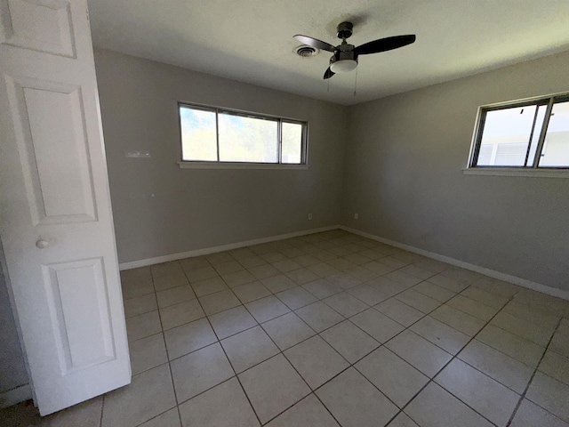 tiled spare room with ceiling fan