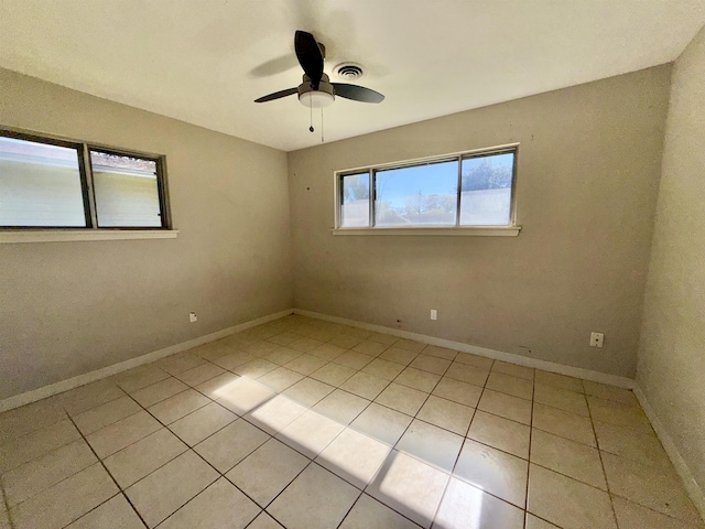 tiled spare room featuring ceiling fan