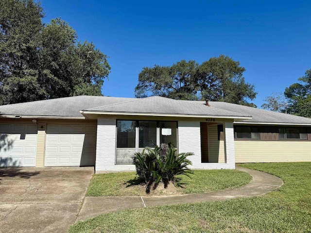 ranch-style home featuring a front lawn and a garage