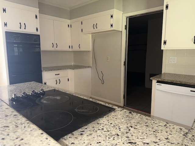 kitchen featuring light stone countertops, decorative backsplash, white cabinetry, and black appliances