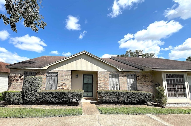 ranch-style house featuring brick siding