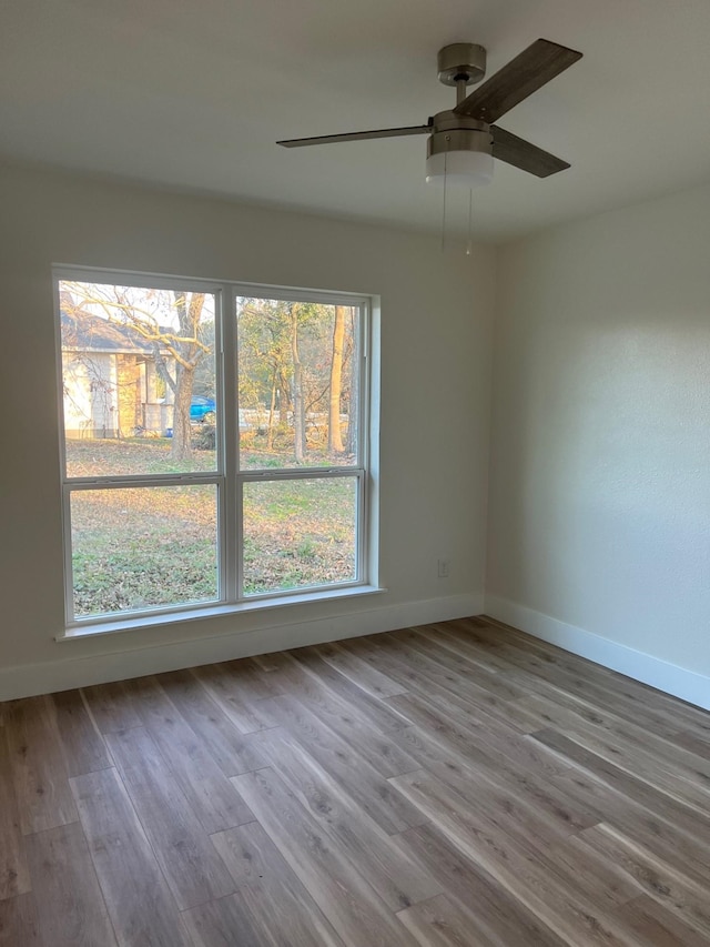 100 Country Club Dr, Beaumont, TX 77705 - spare room featuring a healthy amount of sunlight, baseboards, a ceiling fan, and wood finished floors
