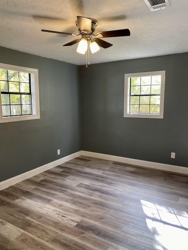 spare room with ceiling fan, hardwood / wood-style floors, and a textured ceiling