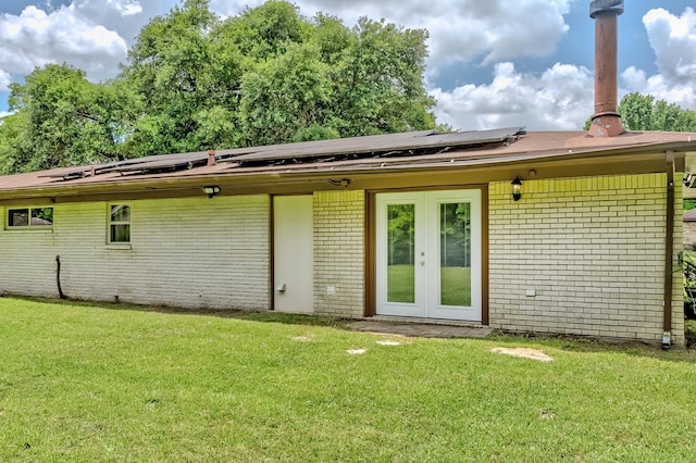 175 Triangle Dr, Vidor, TX 77662 - back of house with brick siding, a yard, solar panels, and french doors