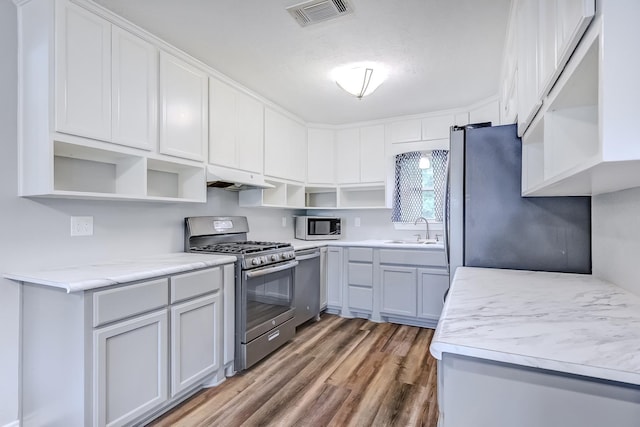 175 Triangle Dr, Vidor, TX 77662 - kitchen with open shelves, stainless steel appliances, a sink, and under cabinet range hood