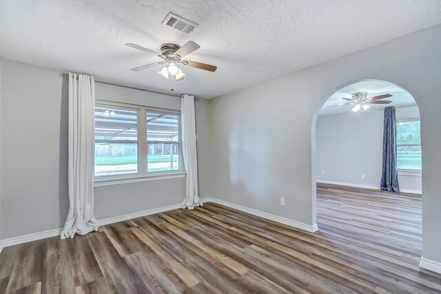 175 Triangle Dr, Vidor, TX 77662 - empty room featuring arched walkways, ceiling fan, wood finished floors, a textured ceiling, and baseboards