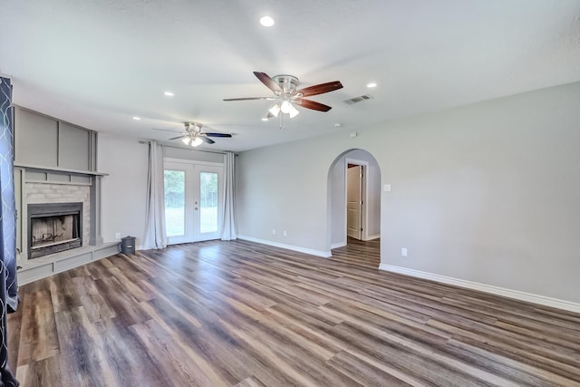 175 Triangle Dr, Vidor, TX 77662 - unfurnished living room with arched walkways, a brick fireplace, recessed lighting, baseboards, and wood finished floors