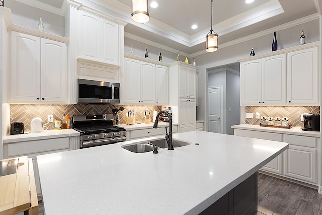 7495 Broussard Rd, Beaumont, TX 77713 - kitchen featuring appliances with stainless steel finishes, crown molding, backsplash, white cabinets, and an island with sink