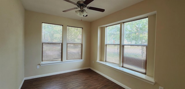 spare room featuring plenty of natural light, ceiling fan, and dark hardwood / wood-style floors