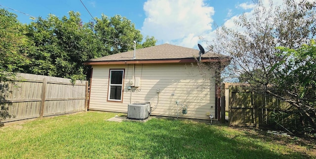 rear view of property featuring a lawn and cooling unit