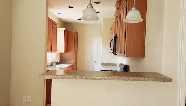 kitchen with kitchen peninsula, sink, hanging light fixtures, and range