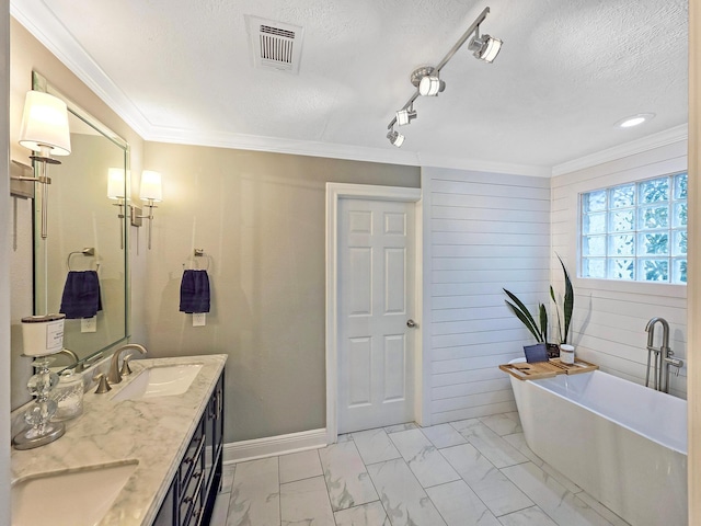 full bathroom featuring visible vents, marble finish floor, a freestanding tub, a textured ceiling, and a sink