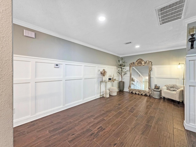 living area featuring dark wood-style flooring, visible vents, ornamental molding, and a decorative wall