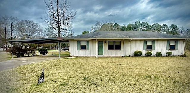 ranch-style house with driveway, an attached carport, and a front yard