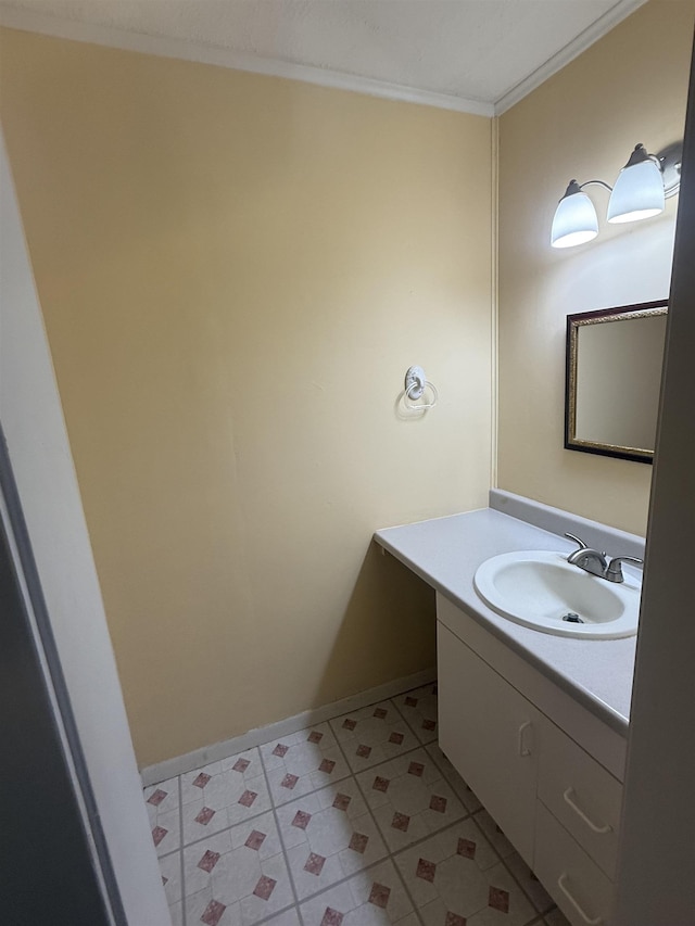 bathroom with ornamental molding, vanity, and baseboards