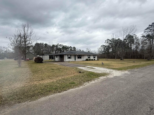 view of front of property with an attached carport, driveway, and a front lawn