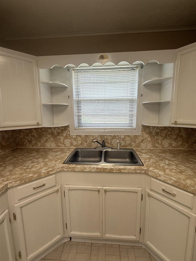 kitchen with open shelves, a sink, and white cabinets