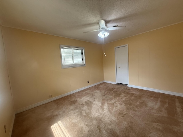 unfurnished bedroom with carpet floors, ceiling fan, baseboards, and a textured ceiling