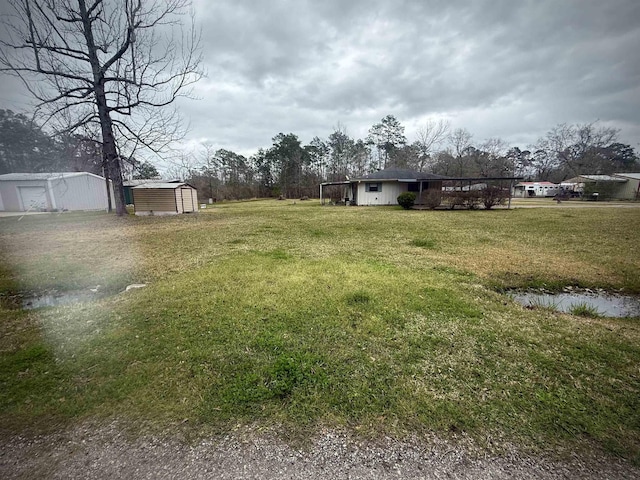 view of yard featuring a storage shed and an outbuilding